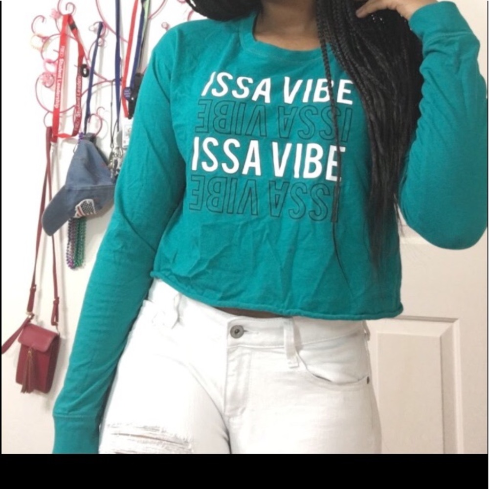 A long sleeve blue crop top that says, “Issa Vibe”